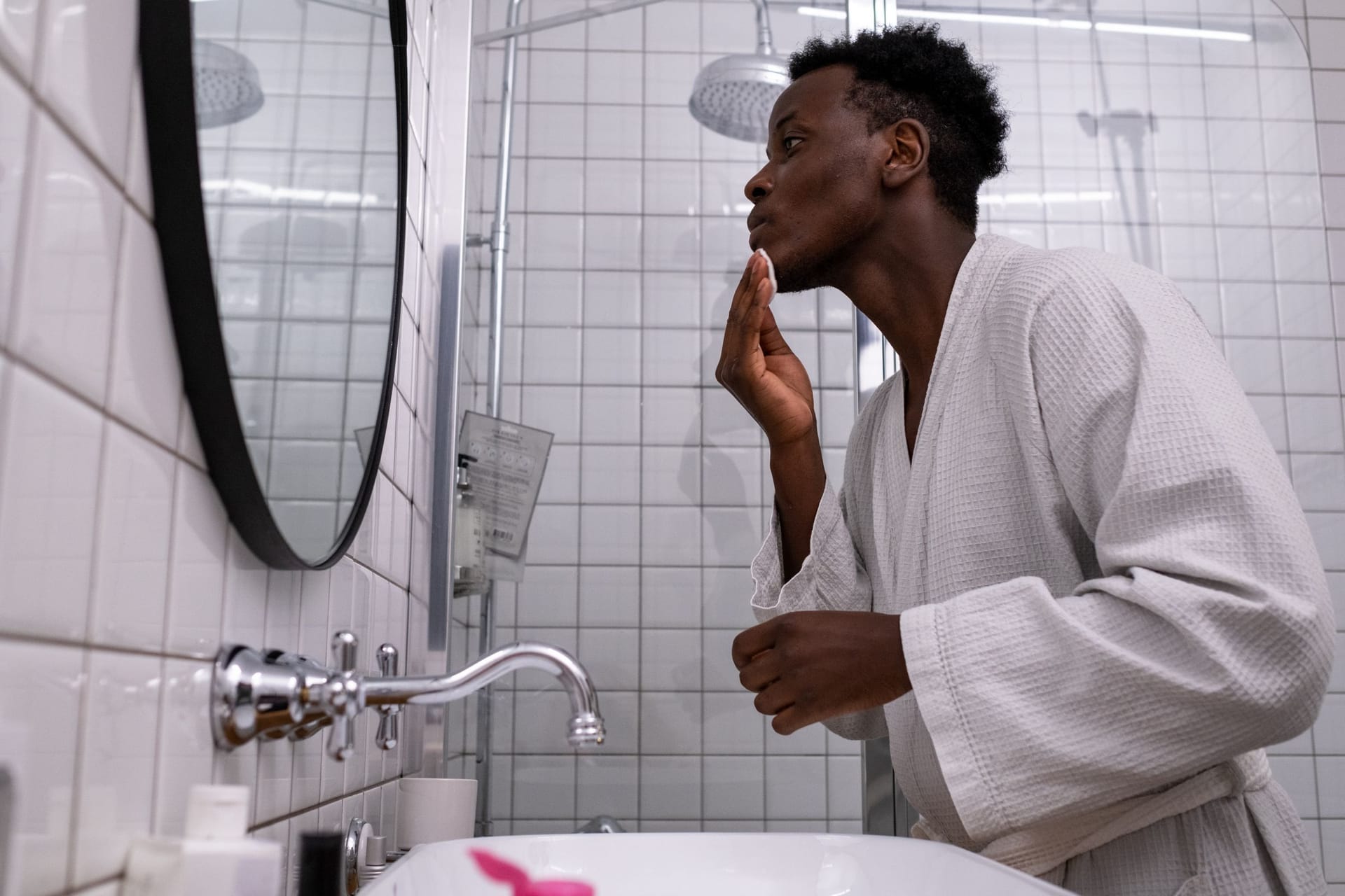 A man applying a skincare routine at the mirror